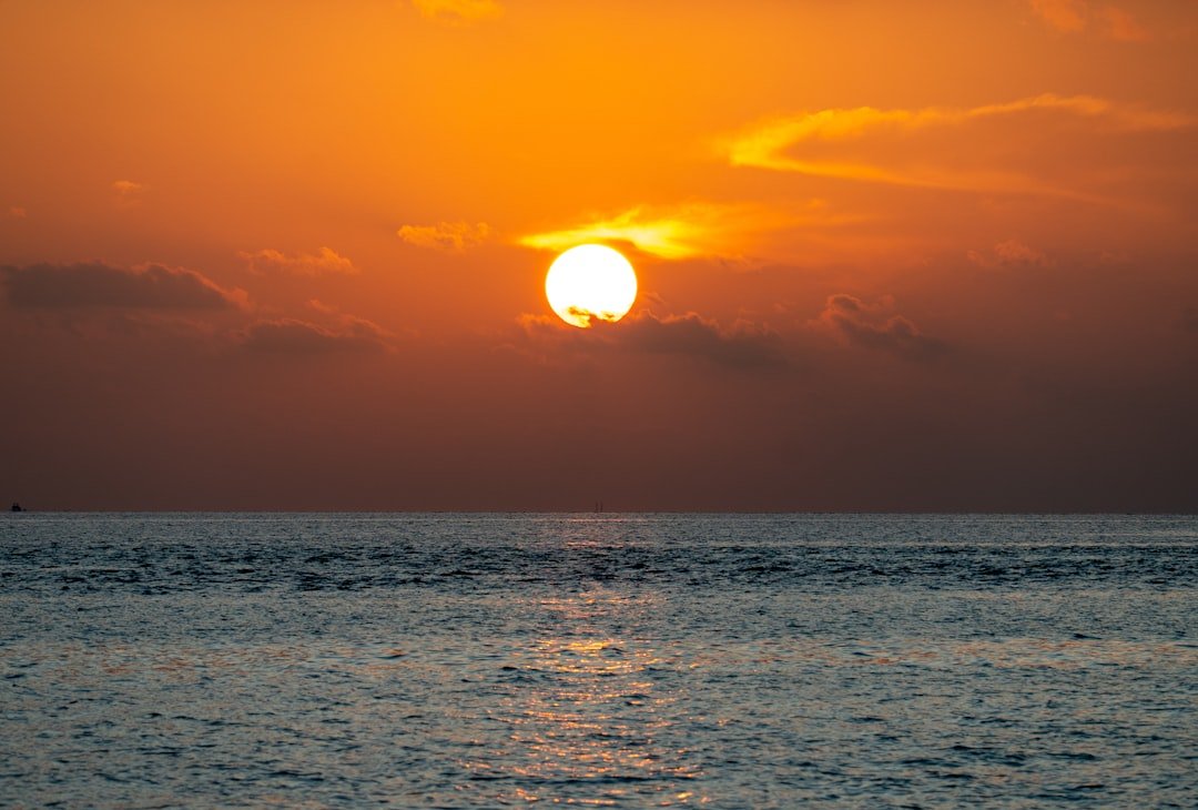 Tropical sunset over ocean with orange sky