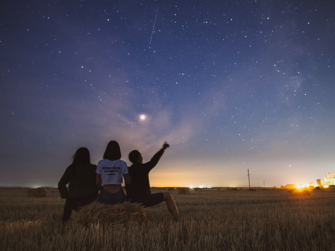 Children pointing at constellations in night sky