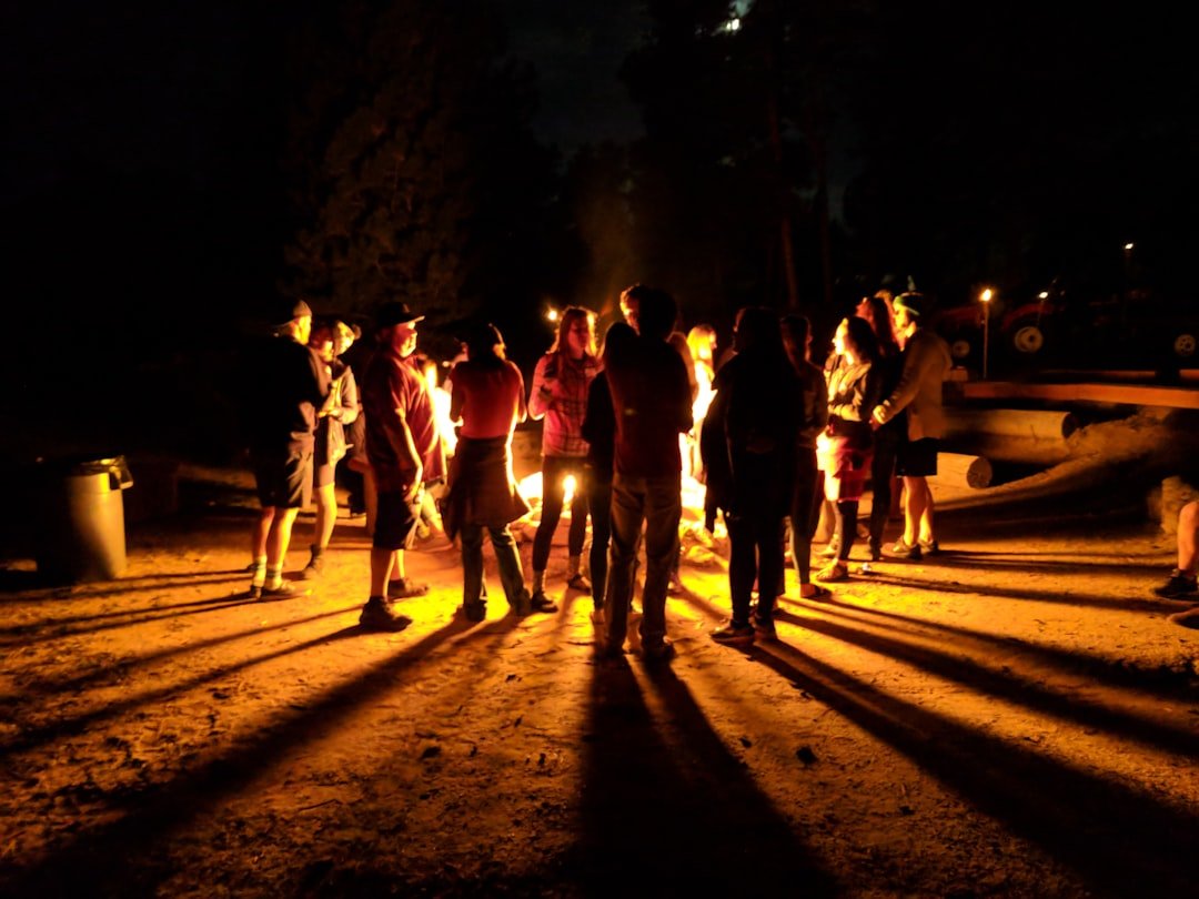Friends gathered around campfire at night