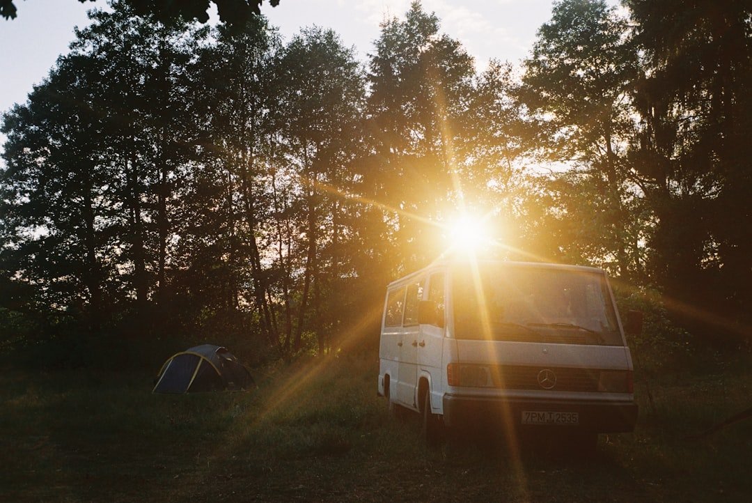 Campervan parked in forest camping at sunset
