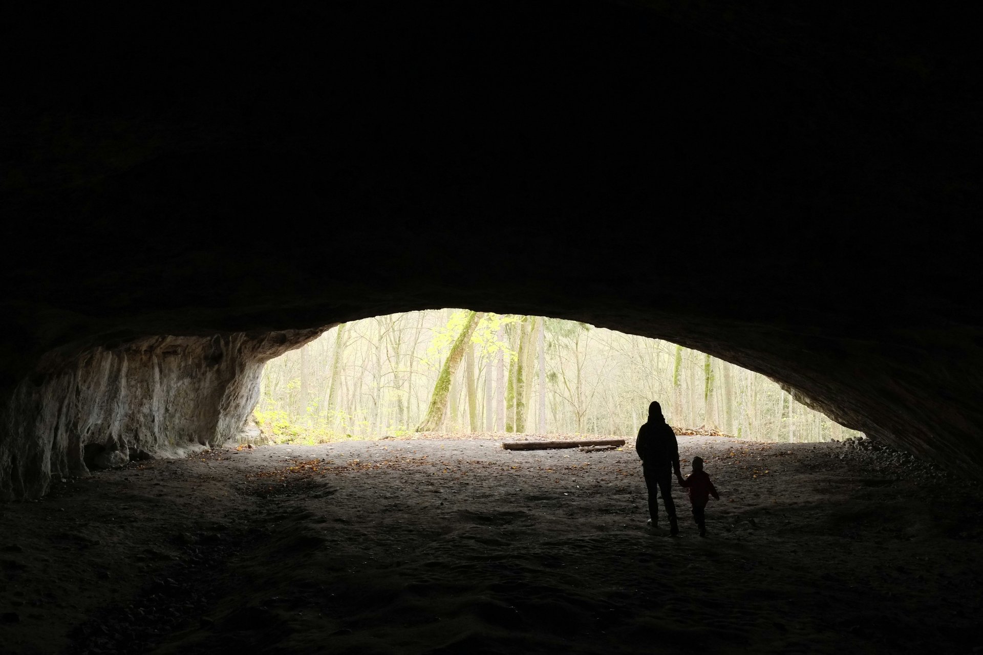 Hiker exploring cave with headlamp