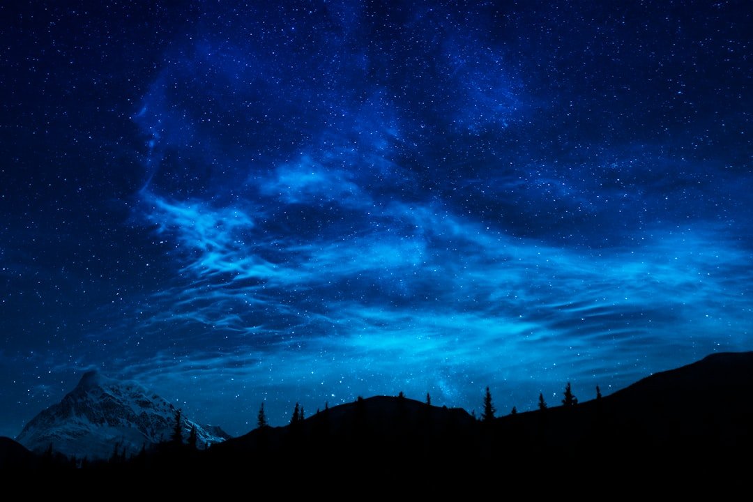 Mountain silhouette against a dark night sky filled with stars