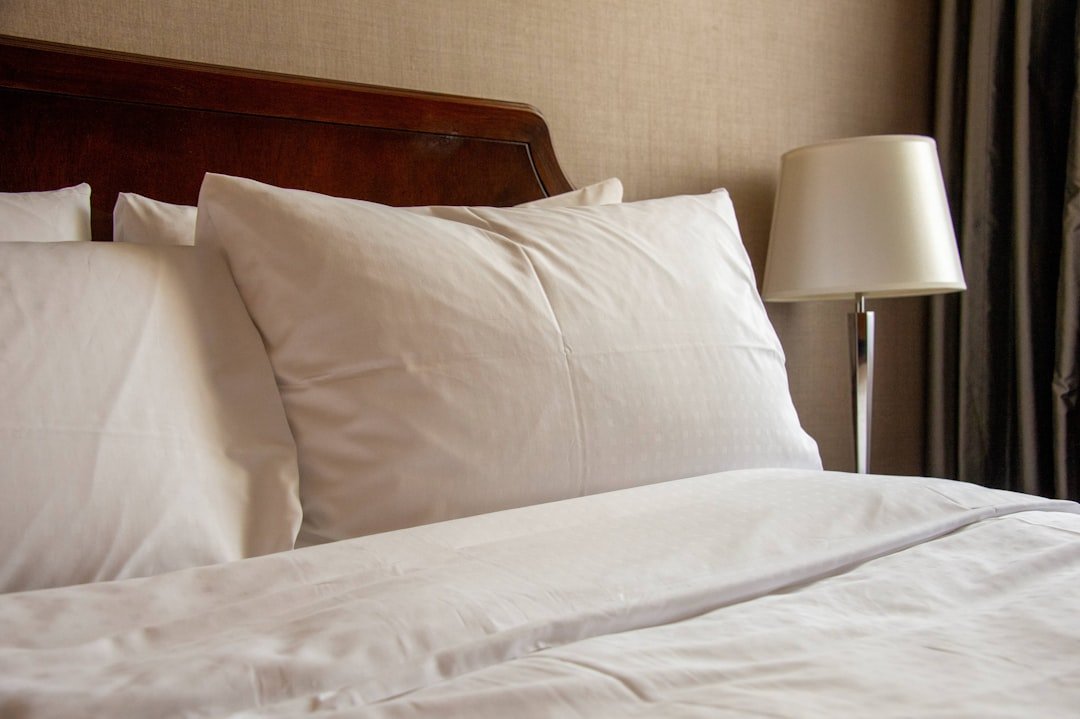 Comfortable bed with white pillows and soft bedding for restful travel sleep
