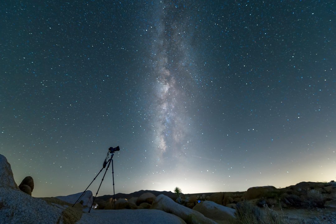Telescope set up for stargazing at night under a star-filled sky