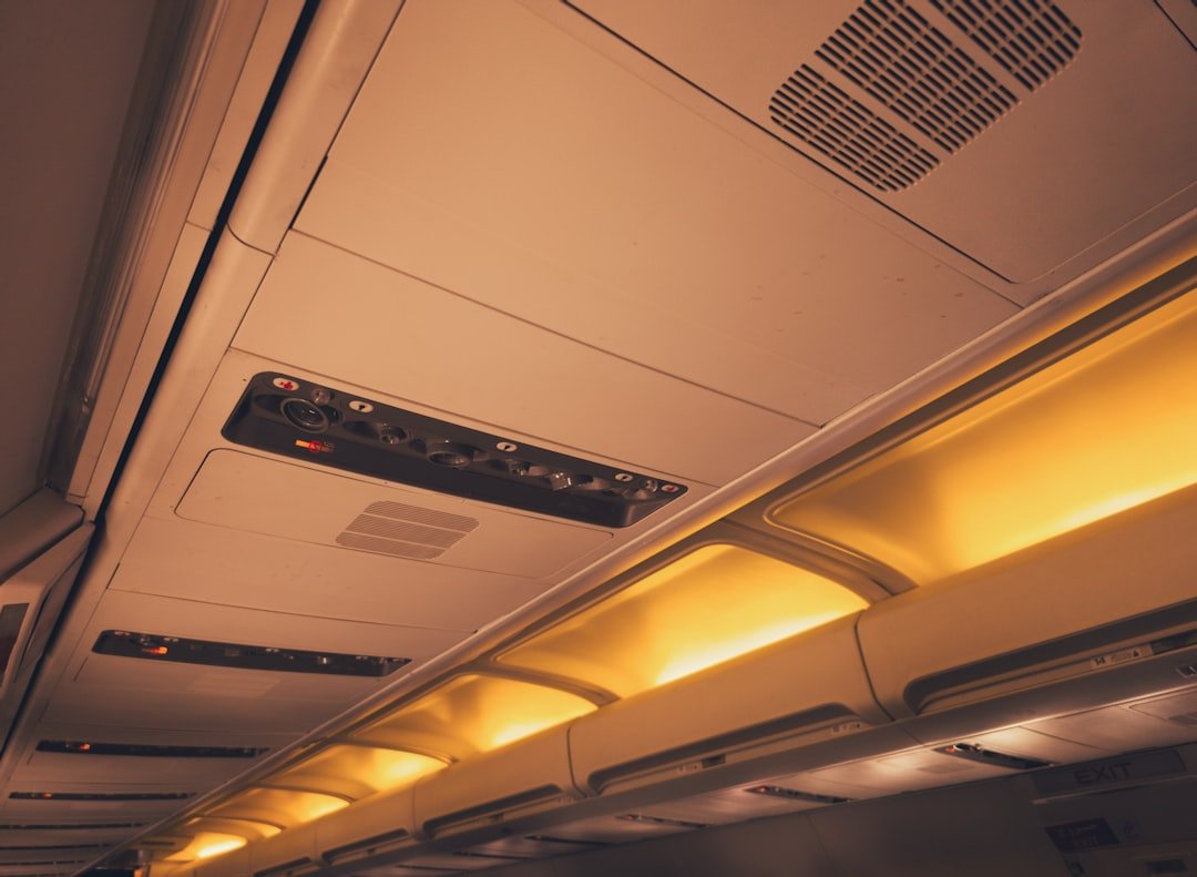 Airplane cabin interior during overnight flight with dimmed lighting