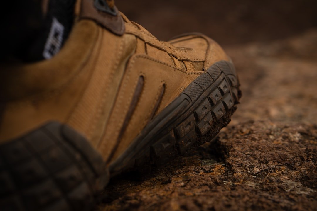 Waterproof hiking boots on rocky trail near waterfall