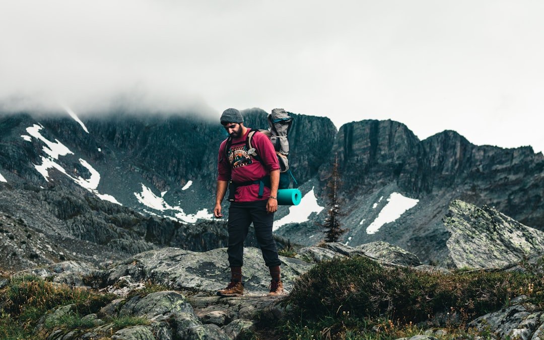 Hiker drinking water from a bottle on a mountain trail