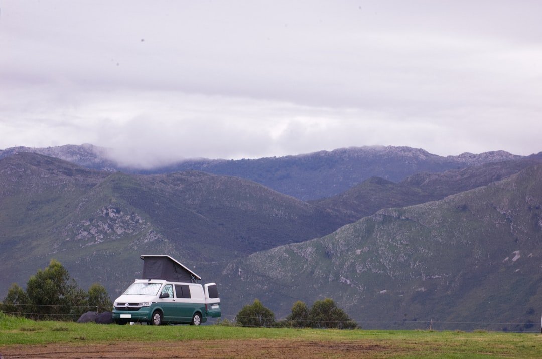 Four solar panels mounted on a campervan roof alongside a vent fan
