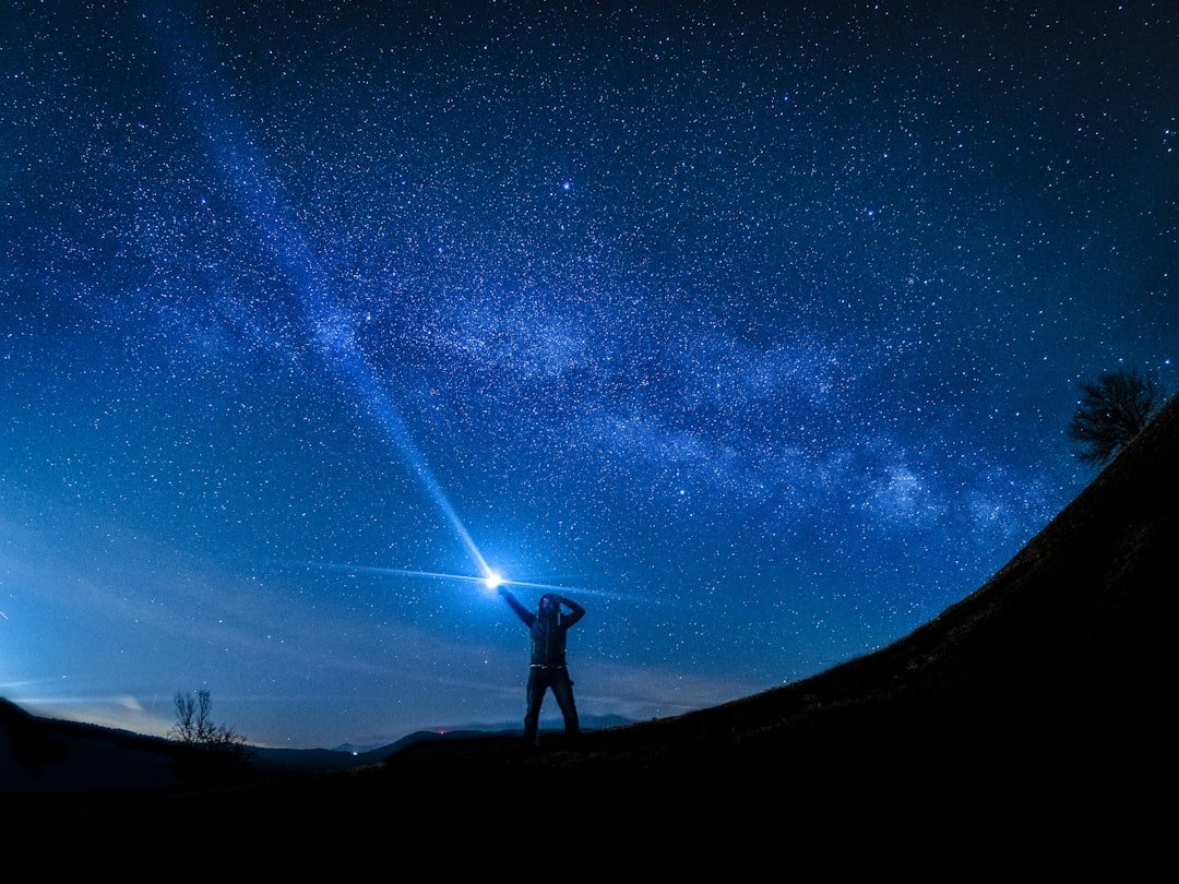 Bright flashlight beam illuminating dark trail