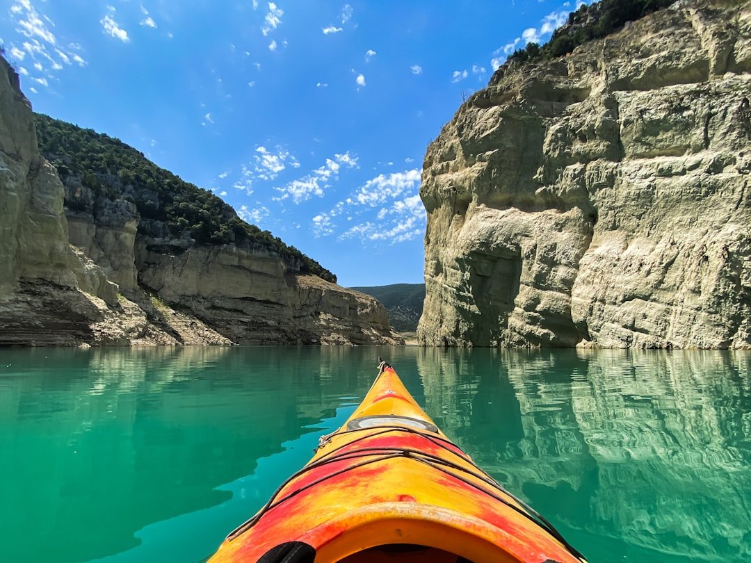 Person kayaking on crystal clear turquoise mountain water