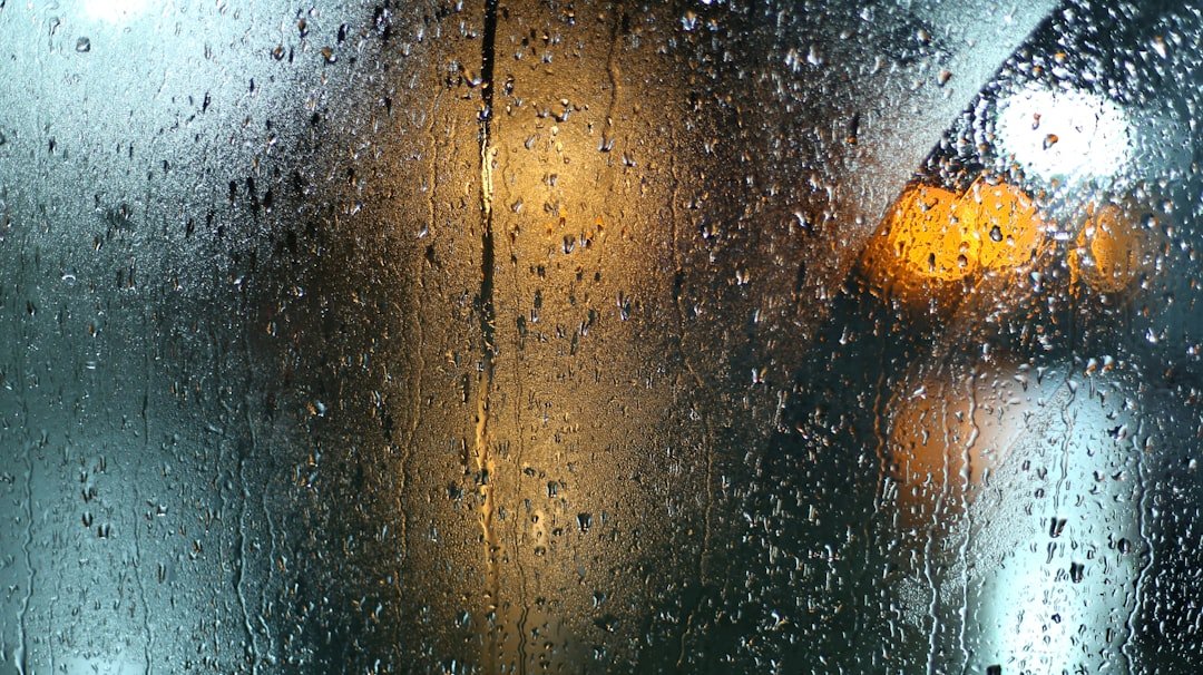 Rain running down a glass window surface