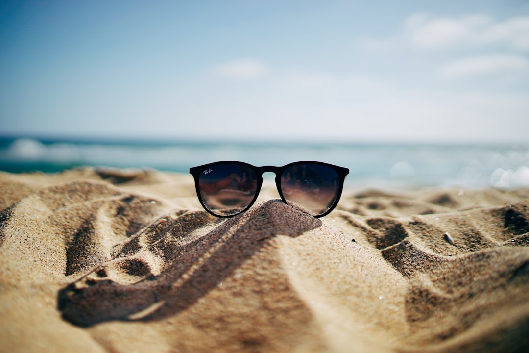 Polarized sunglasses on a beach with ocean background