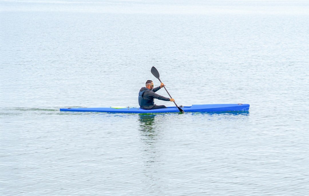 Water sports gear laid out on a dock by a lake