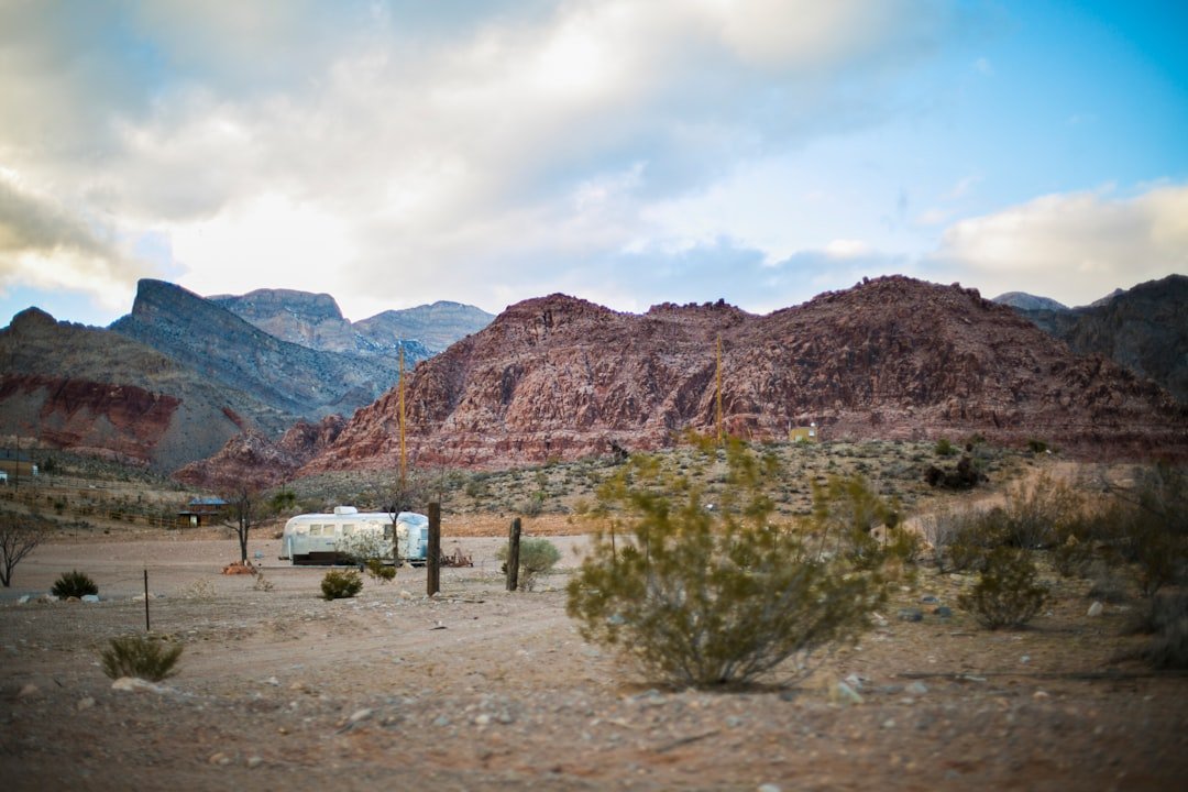 Small travel trailer parked in mountain landscape with scenic views