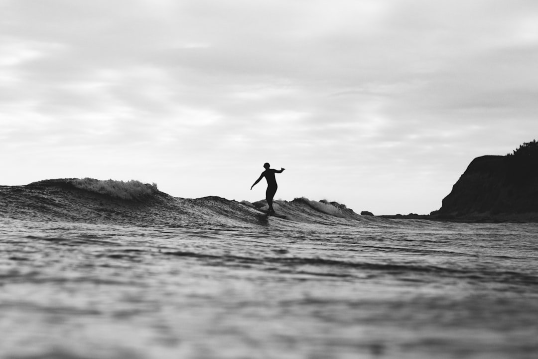 Surfer in wetsuit riding ocean waves
