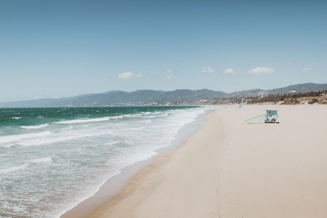 Sunny California beach with umbrella and clear water