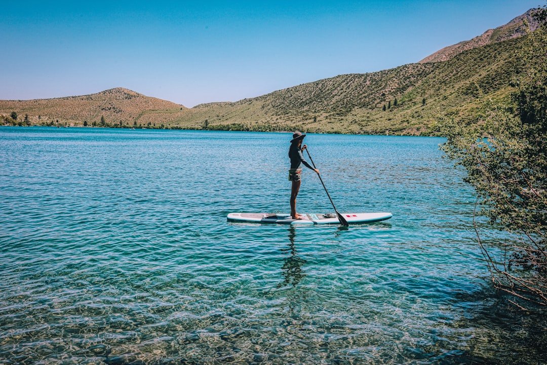 Stand up paddle boarder on a calm lake at golden hour