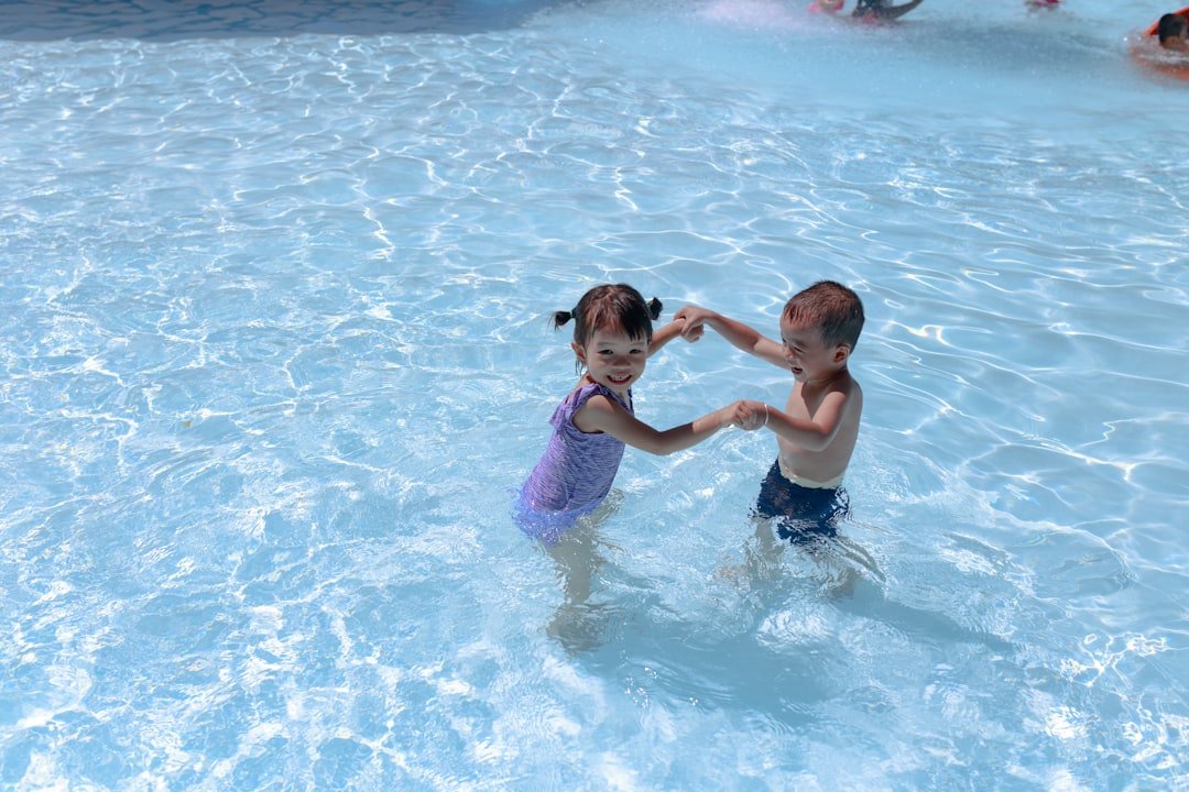 Kids having fun in a swimming pool on a summer day
