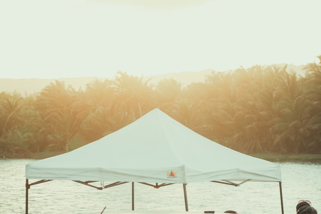 Pop-up canopy tent providing shade by the water at golden hour