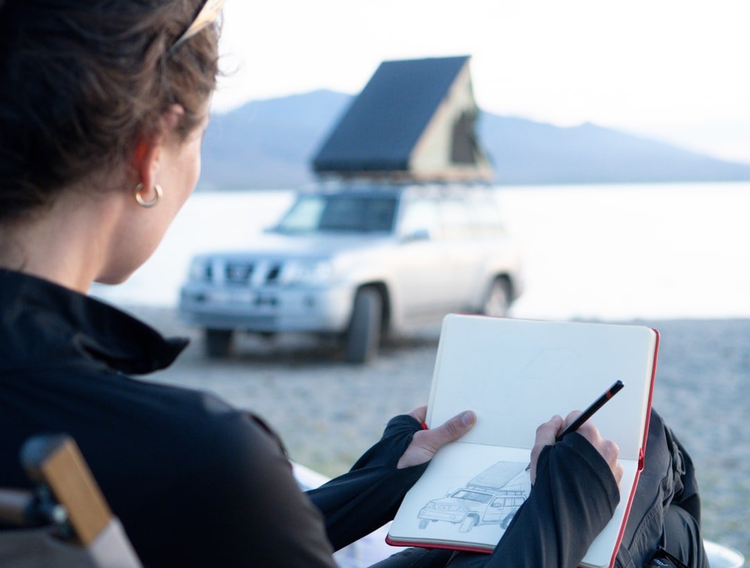 Open travel journal with pen on an outdoor table