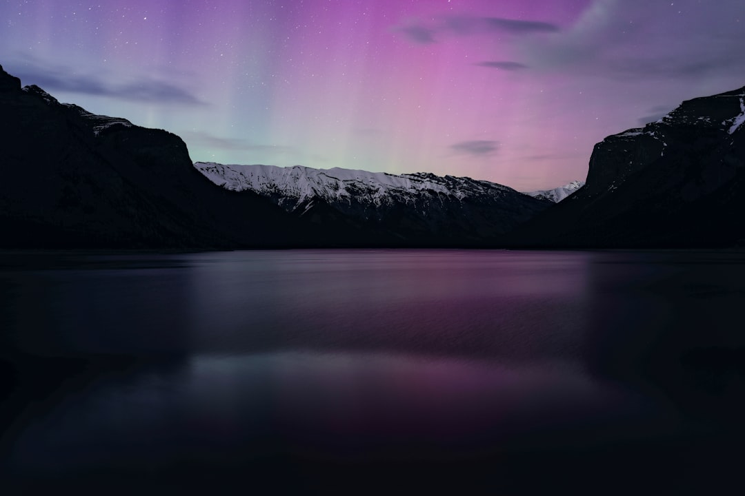 Northern lights aurora borealis reflecting off a calm lake surface