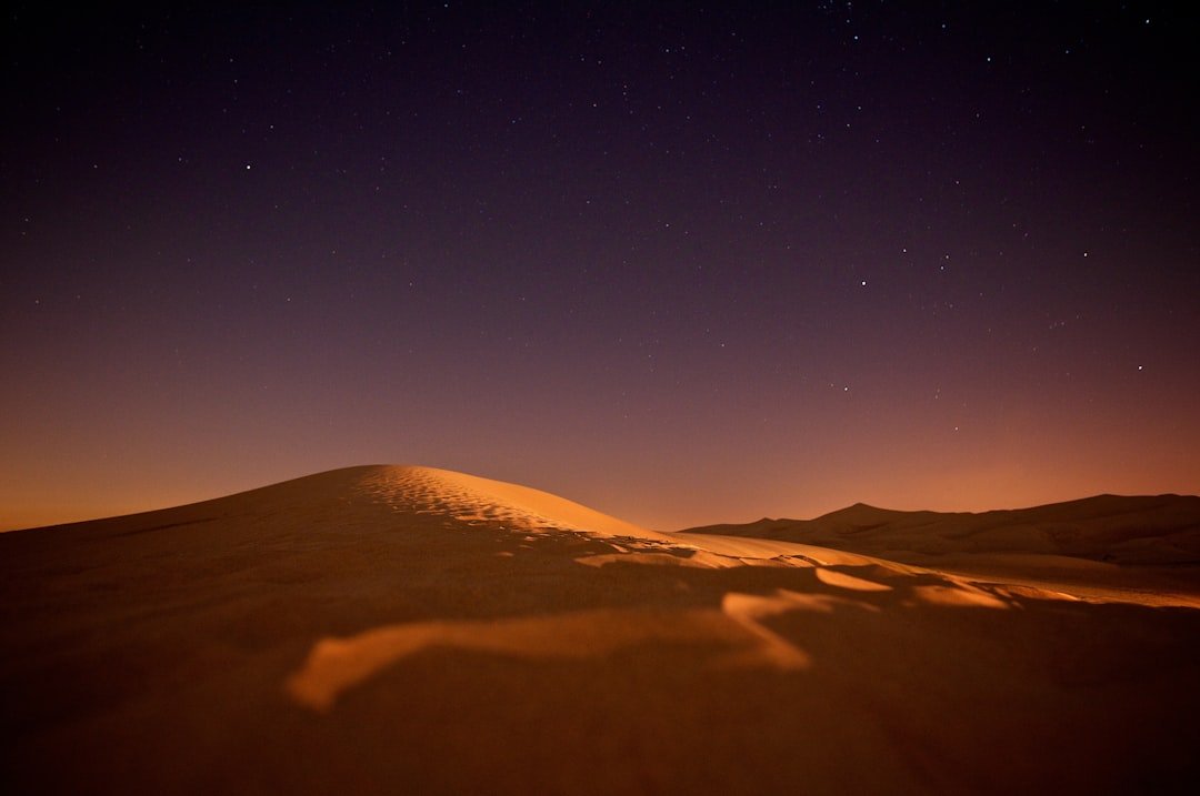 Starry night sky over desert campsite