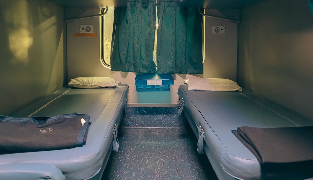 Interior of a sleeper train cabin with bed and privacy curtain