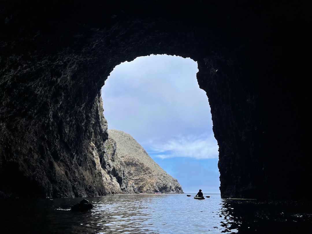 Kayaker paddling into a sea cave