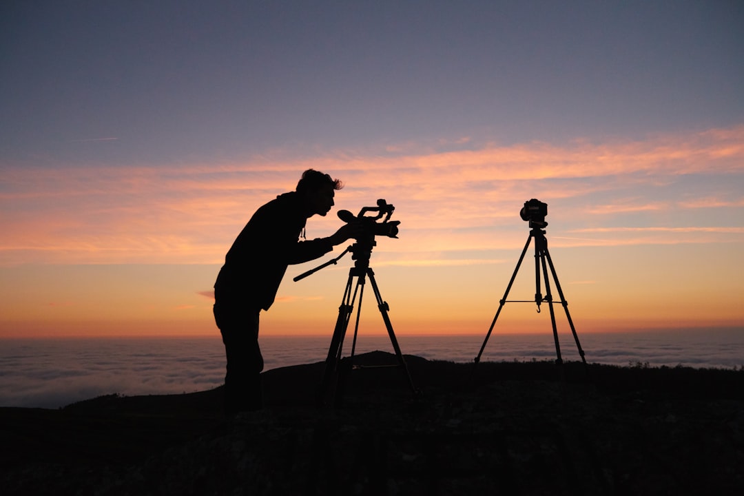 Photographer setting up a tripod on a rocky outcrop