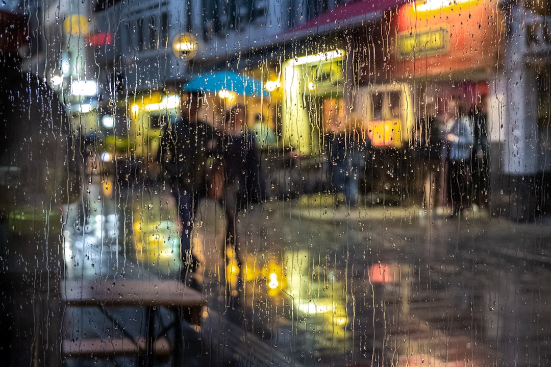 Person walking through rain in a city with travel gear