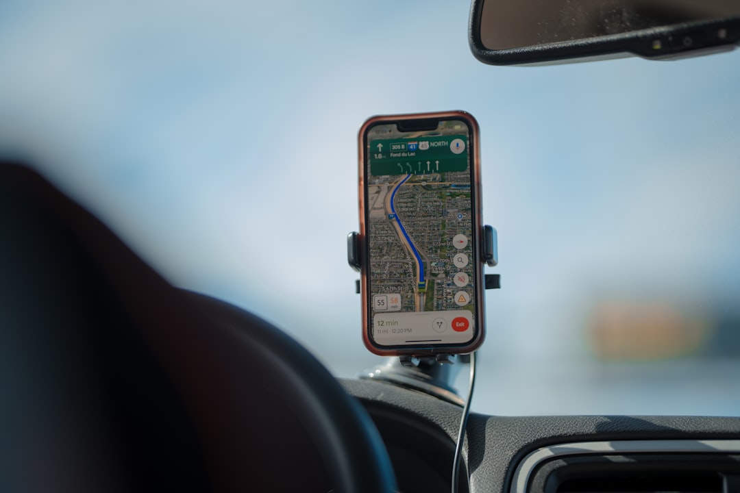Phone mounted in car with charging cable on road trip