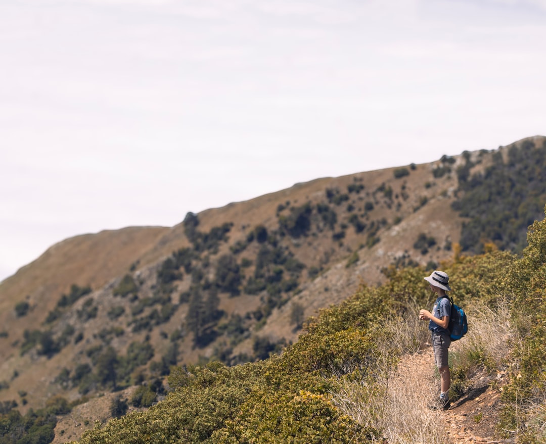 Backpacker checking phone on a mountain trail