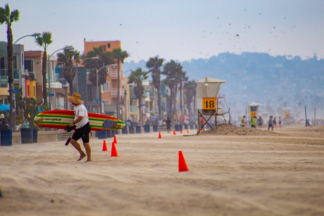 Beach boardwalk with surfers and beachgoers