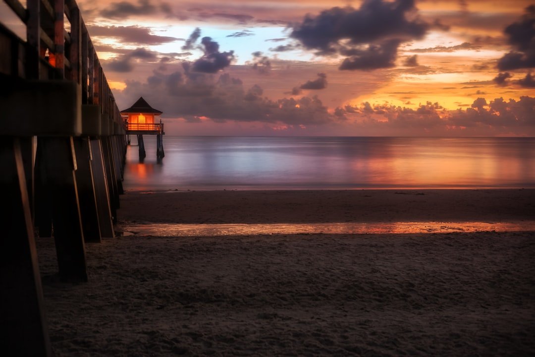 Fishing pier at sunset with calm ocean waters