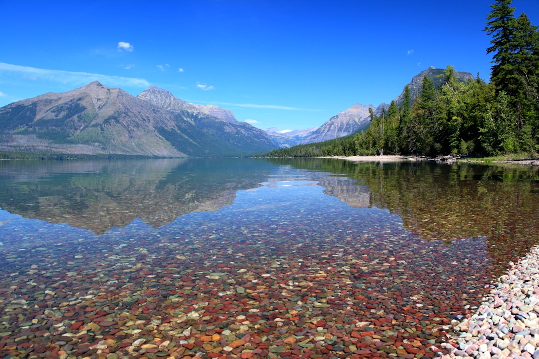 Lake McDonald's clear turquoise water with mountain reflections