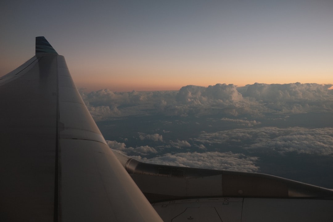 View from an airplane window seat above the clouds