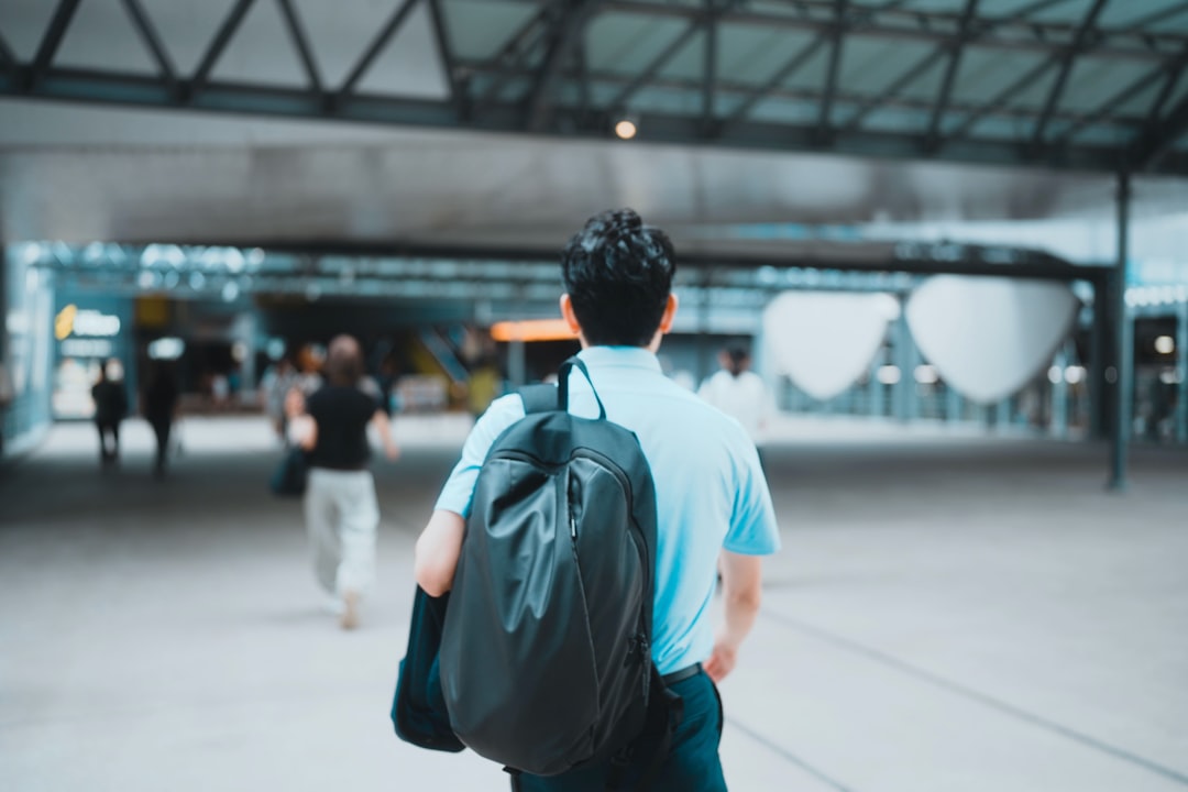 Traveler walking through airport terminal with carry-on backpack
