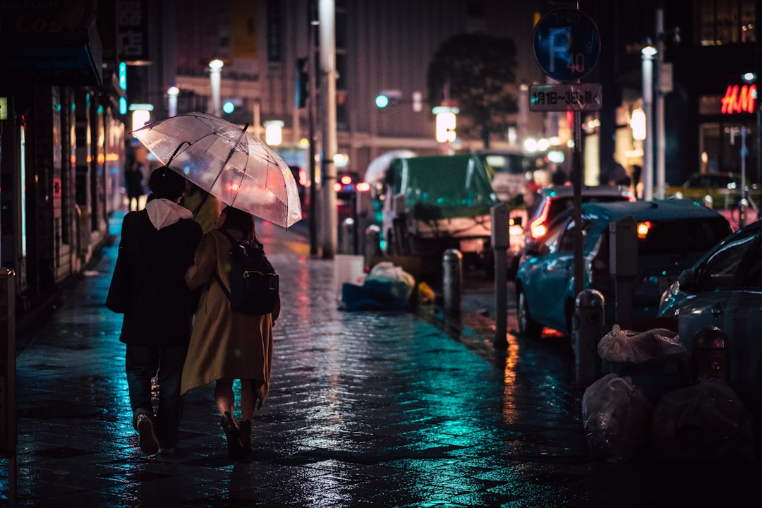 Person walking through rainstorm on city street