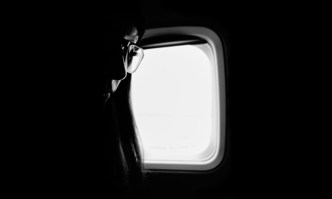 Traveler sleeping in airplane window seat