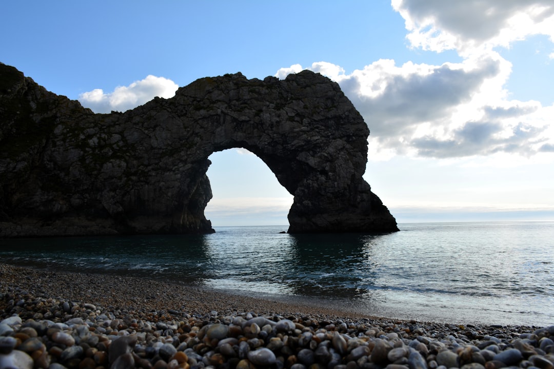 Natural limestone arch rock formation above the water
