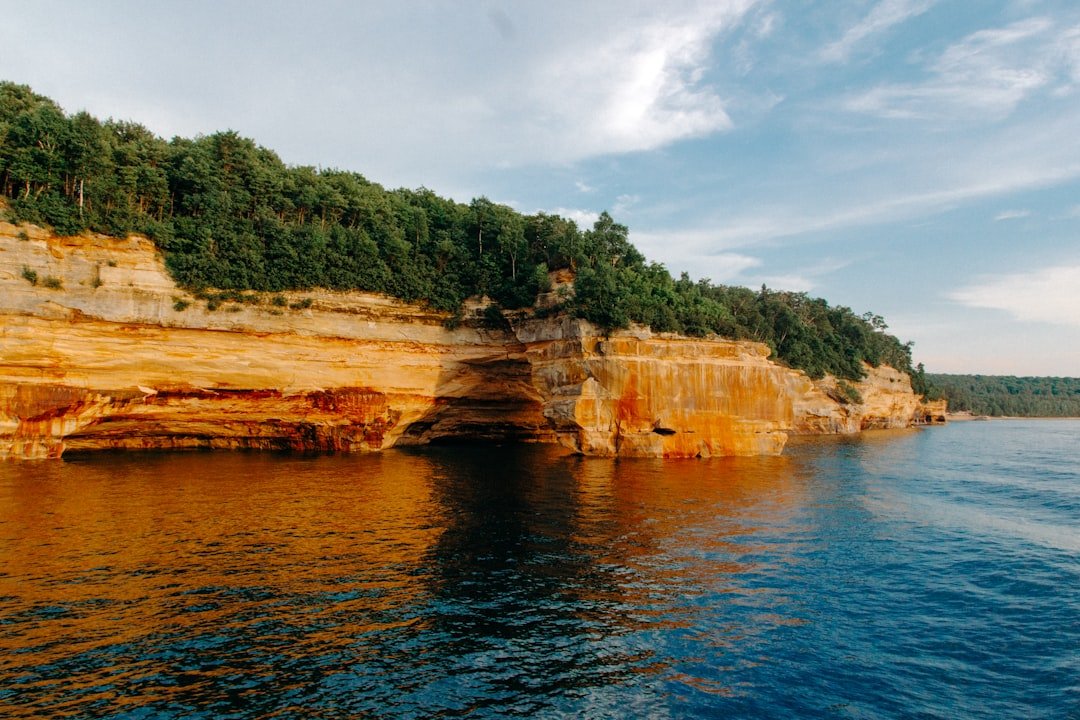Layered limestone rock shoreline meeting calm blue water