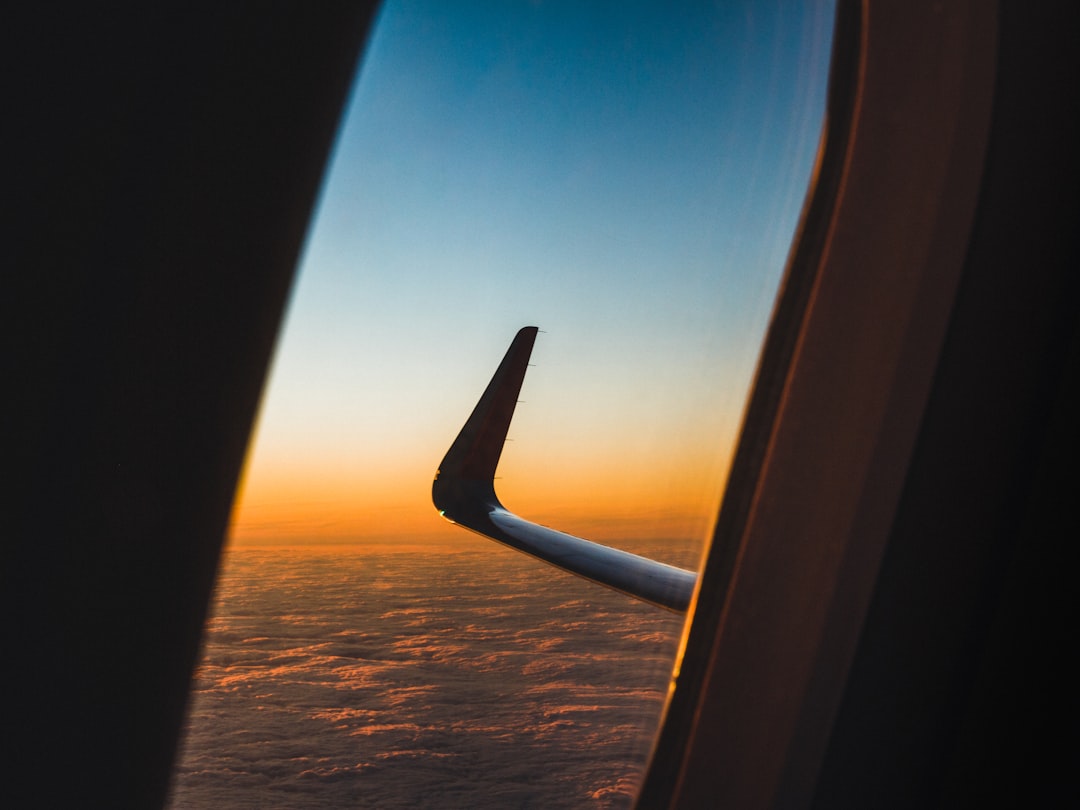 View from an airplane window seat above the clouds