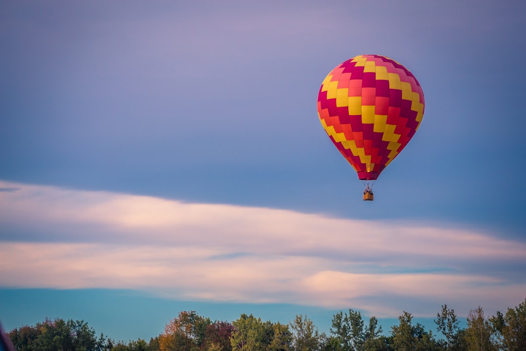 A hot air balloon drifting over autumn landscape