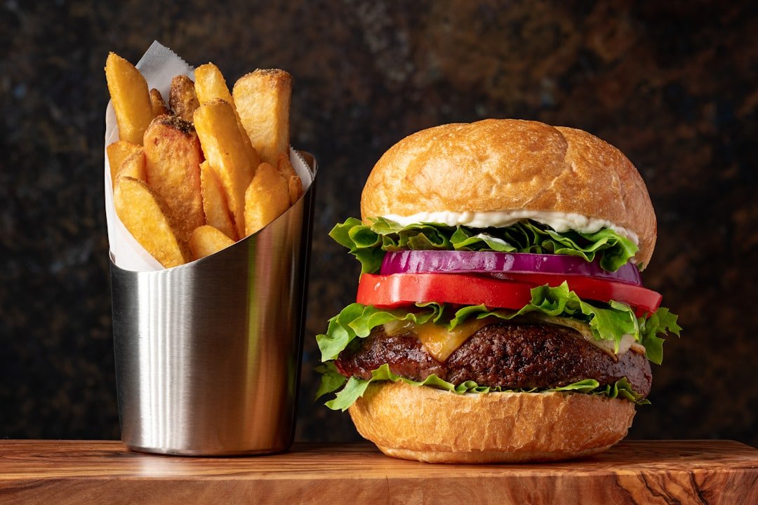 Classic cheeseburger and fries on a wooden table — the pilot's $100 hamburger