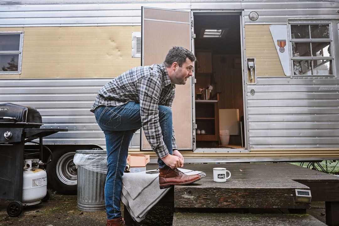 Traveler attending to gear outside a camper at camp