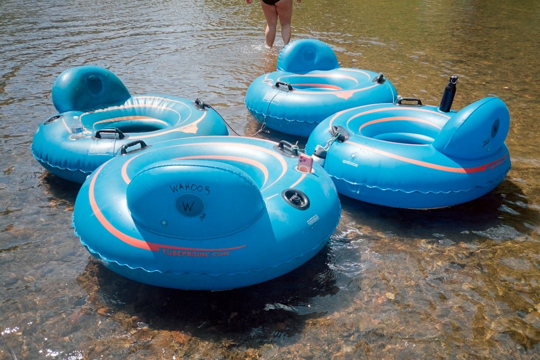 People floating downstream on inner tubes on a summer river