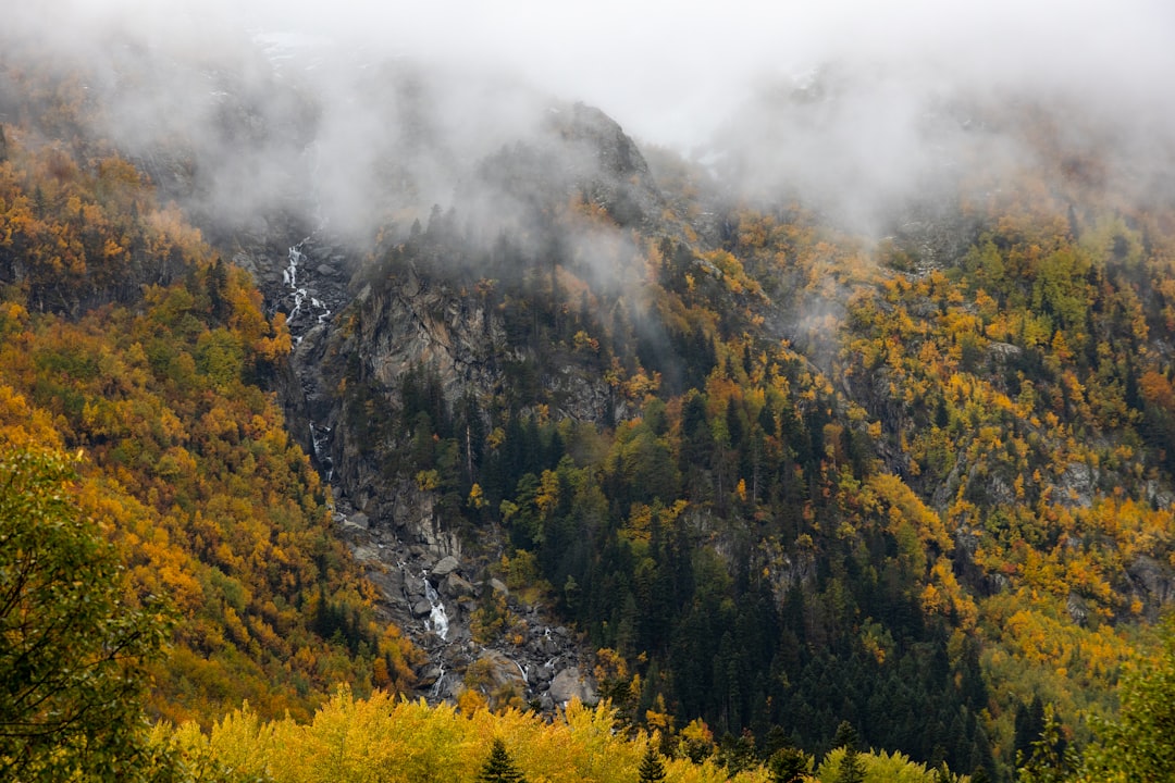 A waterfall pouring through an autumn gorge