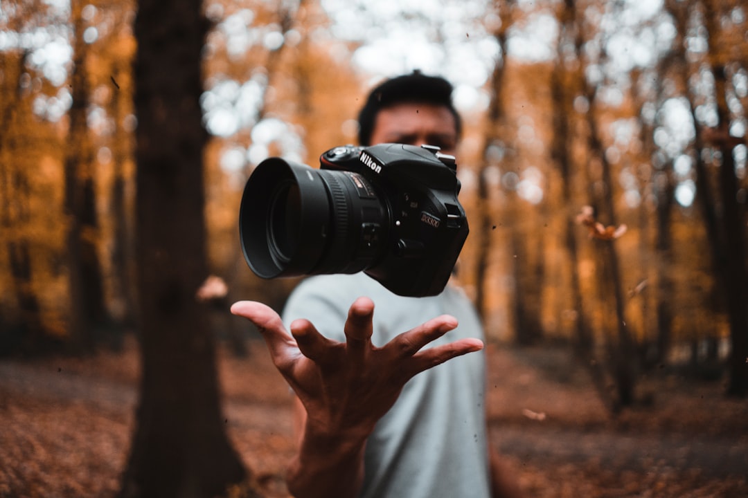 Photographer working among autumn trees with a camera