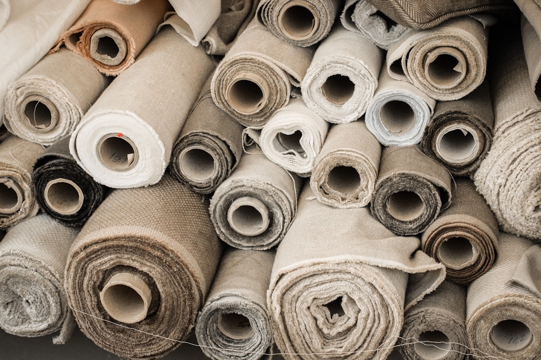 Rolls of neutral canvas fabric stacked in a workshop
