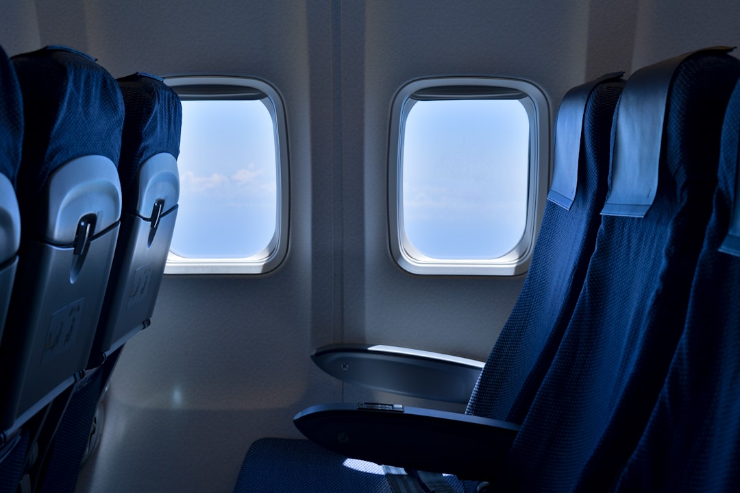 Passenger sleeping in an airplane seat with a blanket